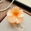 Detail view of a peach gradient flower hair claw clip with a glossy resin finish. - Camellia / 8cm / Orange