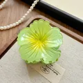 Detailed macro view of a lime green gradient flower hair claw clip resting on fabric - Camellia / 8cm / Green
