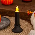 Primo piano di una candela elettronica a LED nera con una fiammella realistica tremolante - Nero Medio