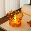 Detailed macro shot of an amber crown-shaped LED tea light holder with warm glow - Champagne