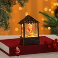 Detail view of a vintage Christmas house lantern with falling snow and a glowing Santa Claus - Bell Santa