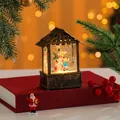 Detailed view of a festive lighted house lantern with snow globe effect and snowman inside - Snowman