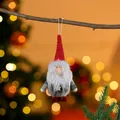 Close-up of a plush Christmas gnome ornament hanging from a tree branch - Grey Gnome