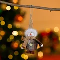 Close-up of fabric Christmas snowman ornament hanging on a twig with warm bokeh lights - Coffee Snowman