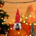 Close-up detail of a red knitted Christmas gnome ornament hanging from a dry tree branch. - Braid Style Red Hat Gray Body