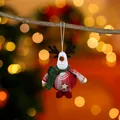 Detailed close-up of a festive Christmas reindeer plush ornament hanging on a branch. - Green Hat Red Body Deer