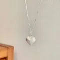 Close-up of S925 sterling silver heart necklace with elegant brushed matte texture - Silver