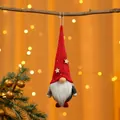 Detailansicht eines hängenden Weihnachtswichtels mit warmem Bokeh-Licht im Hintergrund - Bart-Stil / Roter Hut Grauer Körper