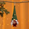 Detailansicht eines kleinen gestrickten Weihnachts-Wichtels als Hängedekoration mit Sternen. - Geflochtener Stil / Grüner Hut