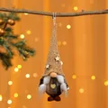 Detaillierte Nahaufnahme eines kleinen Weihnachts-Gnom-Anhängers mit Goldmütze - Geflochtener Stil / Gelber Hut