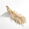 Vista detallada de un pavo real dorado artificial con plumas para decoración de Navidad - Pavo real dorado