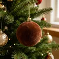 Primo piano dettagliato di una pallina di Natale floccata marrone su un albero festivo - Caffè