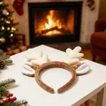 Detalle de diadema de astas de reno de felpa en mesa con fondo de chimenea navideña - Astas Blanco Roto