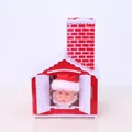 Close-up of electric Christmas Santa Claus ornament inside a red and white plastic house - Chimney House