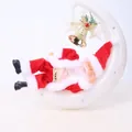 Detailed view of a Santa Claus figure lying on a white crescent moon with a gold bell - Santa Claus Moon