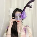 Nahaufnahme einer eleganten lila Spitzenmaske mit Blume und Federn an einem Model - Feder Blume Spitze Stil / Lila