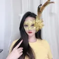 Detailansicht einer goldenen Spitzen-Maskerade-Maske mit Federn für Halloween-Partys - Feder Blume Spitze Stil / Gelb