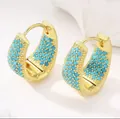Detailed macro shot of gold plated teardrop hoop earrings with turquoise stones - Teardrop Hoops / Lake Blue