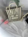 Vue détaillée d'un sac cabas en tricot crème avec des rayures noires et le logo (M) - Rayures Beige