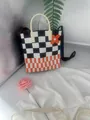 Detailed view of a handmade knit tote bag featuring black and orange checkerboard motifs - Orange Black White Checkerboard