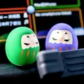 Handbemaltes Set aus grünen und lila Daruma-Puppen als Glücksbringer für das Auto - Paar Grün und Lila