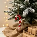Festive red and white glitter candy cane ornament hanging on a snowy Christmas tree - Christmas Cane Pendant