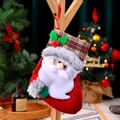Dettaglio di calza di Natale in peluche di Babbo Natale appesa in ambiente festivo - Babbo Natale / Rosso