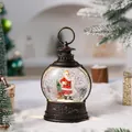 Detailed view of a vintage bronze Christmas lantern with a Santa Claus snow globe. - Santa Claus