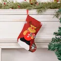 Calcetín de Navidad de lino rojo con reno colgado en una chimenea decorada. - Ciervo