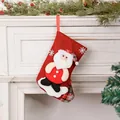 Detalle de un calcetín de Navidad de arpillera roja con decoración de Papá Noel. - Papá Noel