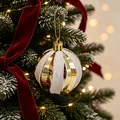 Eleganter gold-weiß gestreifter Weihnachtskugel-Anhänger an einem festlichen Baum - Gold und Silber gestreifte Kugel