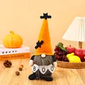 Detail of a Halloween gnome plush doll holding a BOO banner in a cozy home setting. - Orange Hat Style