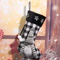 Detailed close-up of a black and white plaid Christmas stocking with cute gnome decor - Gray