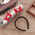 Detalle de diadema de Halloween con monstruos rojos y lazos sobre mesa de madera - Estilo Gato Rojo / Rojo