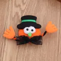 Close-up of a cute handmade Halloween pumpkin brooch with a black top hat and lace bow. - Glowing Hat Pumpkin