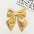 Große glänzende goldene Pailletten-Weihnachtsschleife für festliche Schaufenster - Perlmutt Gold