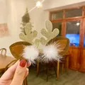 Close-up detail of cute glittery reindeer antler hair clips featuring white fuzzy pom-poms - Sequined Antler Style / One Pair / Gold