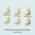 Detail view of gold-plated moon pendants featuring white, pink, and purple cubic zirconia. - Moon (#456) / White (White Zirconia)