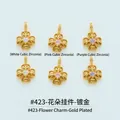 Detailed view of flower-shaped gold-plated charms with colored cubic zirconia inlays - Flower (#423) / White (White Zirconia)