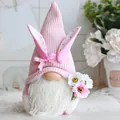 Macro detail of a soft pink knitted Easter gnome doll holding colorful spring flowers - Pink Waffle With Flowers Style (G)