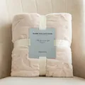 Soft cream flannel jacquard blanket folded with a ribbon on a beige chair - 70*100CM / Off White