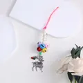 Close-up of a festive Christmas reindeer pendant with colorful bells and pearls. - Elk