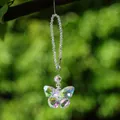 Close-up of an iridescent crystal butterfly suncatcher hanging in a natural setting - 15cm / Pink Green Butterfly