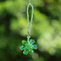 Close-up of a green crystal flower suncatcher with rainbow prism effect for car decoration. - Crystal Flower Pendant / Green