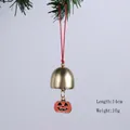 Détail d'une cloche en métal avec citrouille d'Halloween suspendue à une branche - Cloche Citrouille