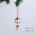 Gros plan d'une cloche de Noël dorée avec un joli charme de bonhomme de neige sur une branche - Cloche Bonhomme de Neige Noël