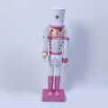 Vista dettagliata di un soldato schiaccianoci in legno rosa e bianco da 30 cm con base lucida. - Stile Soldato Spada Bianca / 30cm