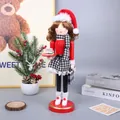 Detailed view of a wooden female Christmas nutcracker doll holding a mini cake tray - Dessert Style (SB58575)