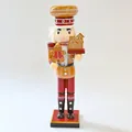 Detailed view of a 35cm wooden nutcracker soldier holding a gingerbread man and house - Red Jacket Small House Style (SB58211-15)
