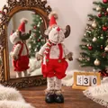 Detailansicht eines süßen Rentier-Plüschtiers für Weihnachten mit roter Latzhose und Hut - Ausziehbares Rentier
